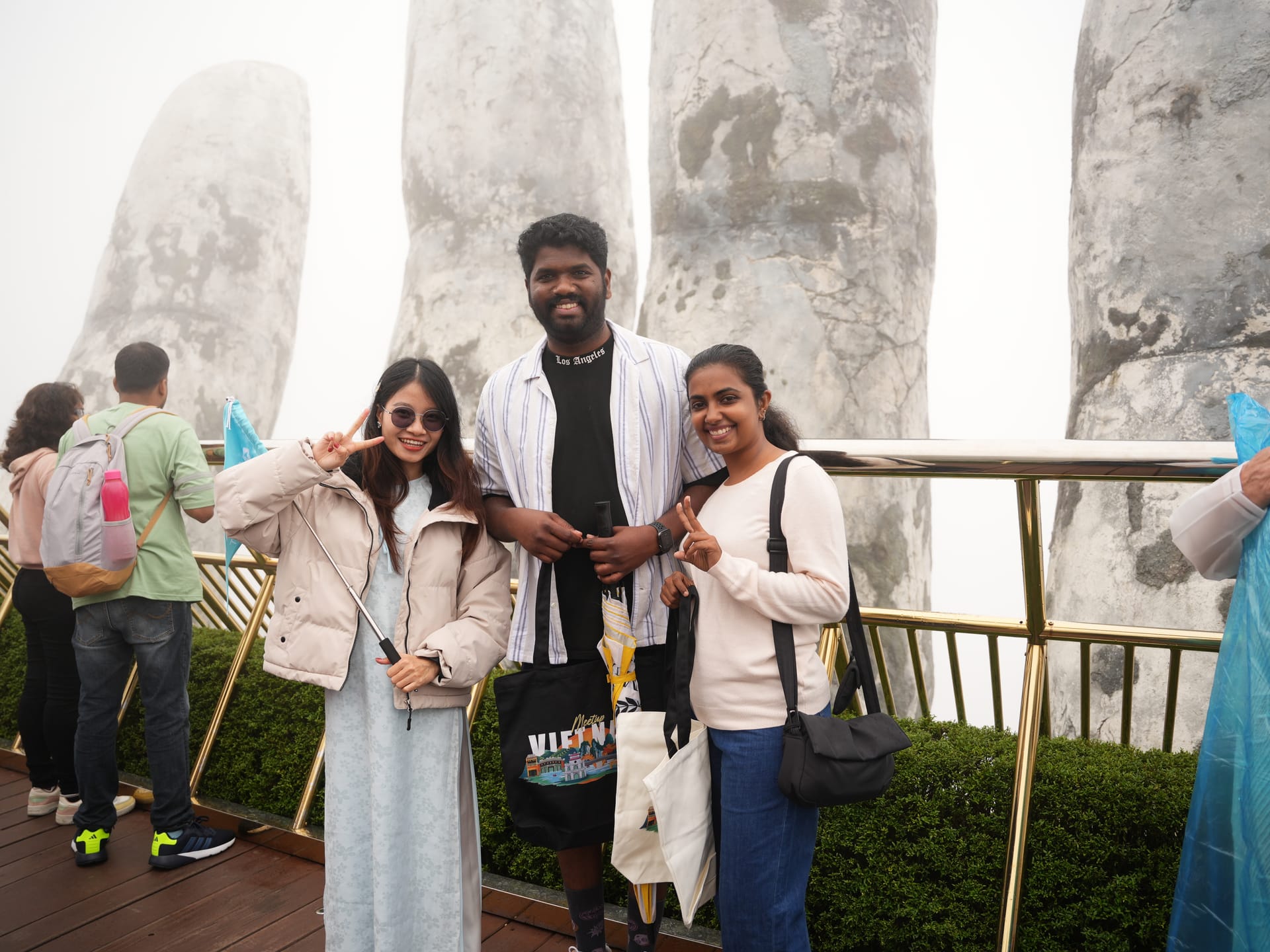 Tourists posing on misty Golden Bridge at Ba Na Hills Da Nang