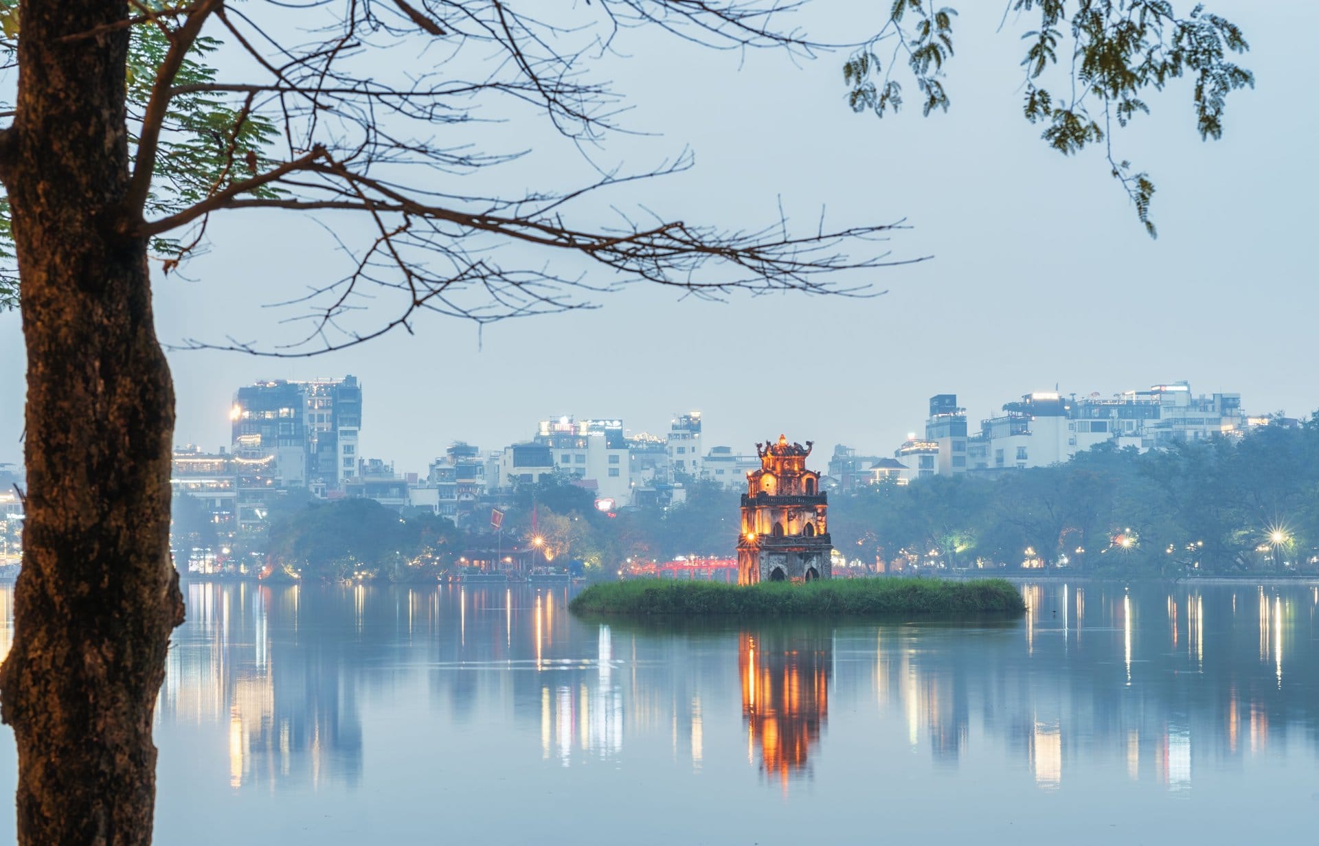 Hanoi skyline lit up at night with busy streets stretching toward the horizon.