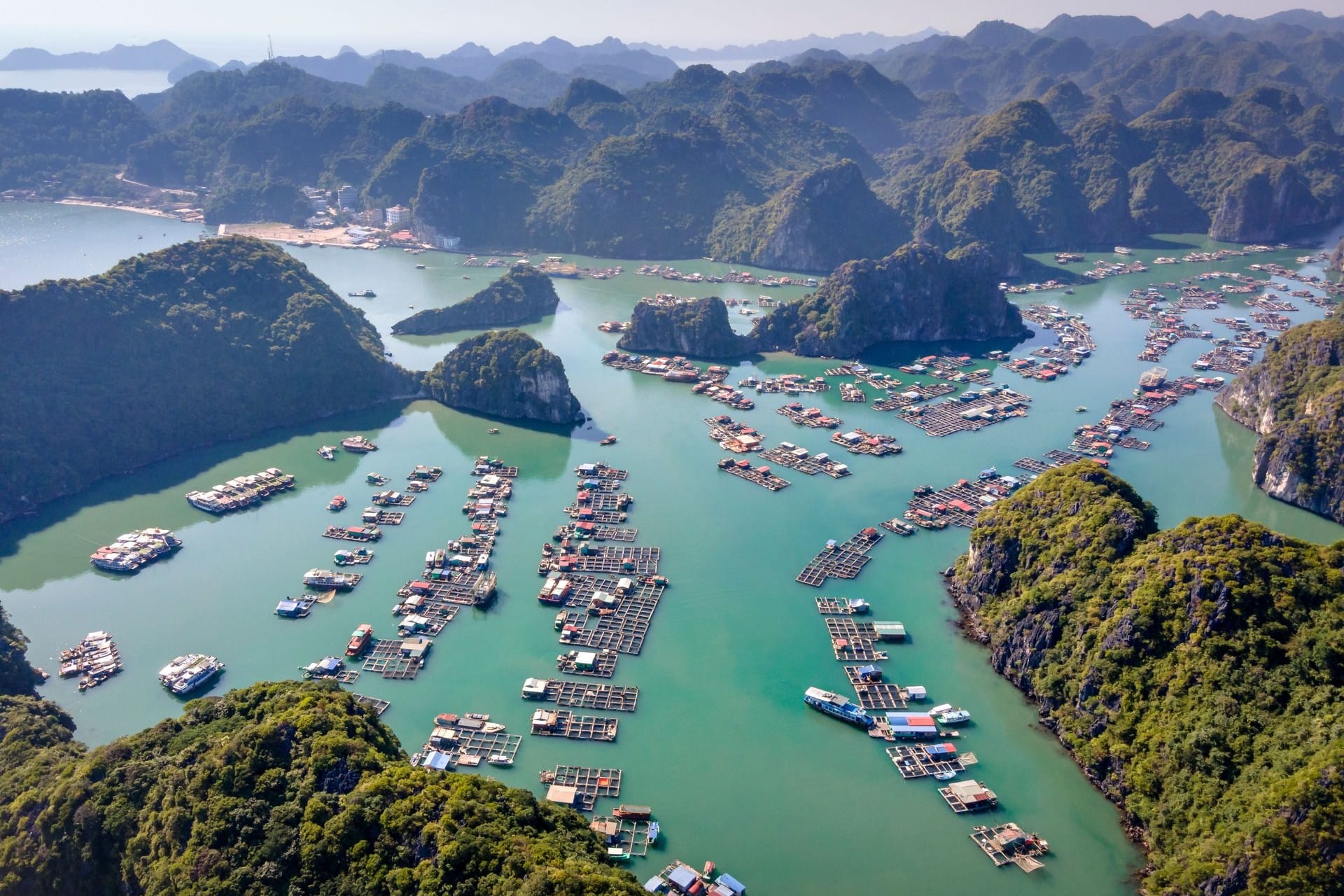 Bright blue sky and sharp visibility over scattered limestone islands on a dry autumn morning.