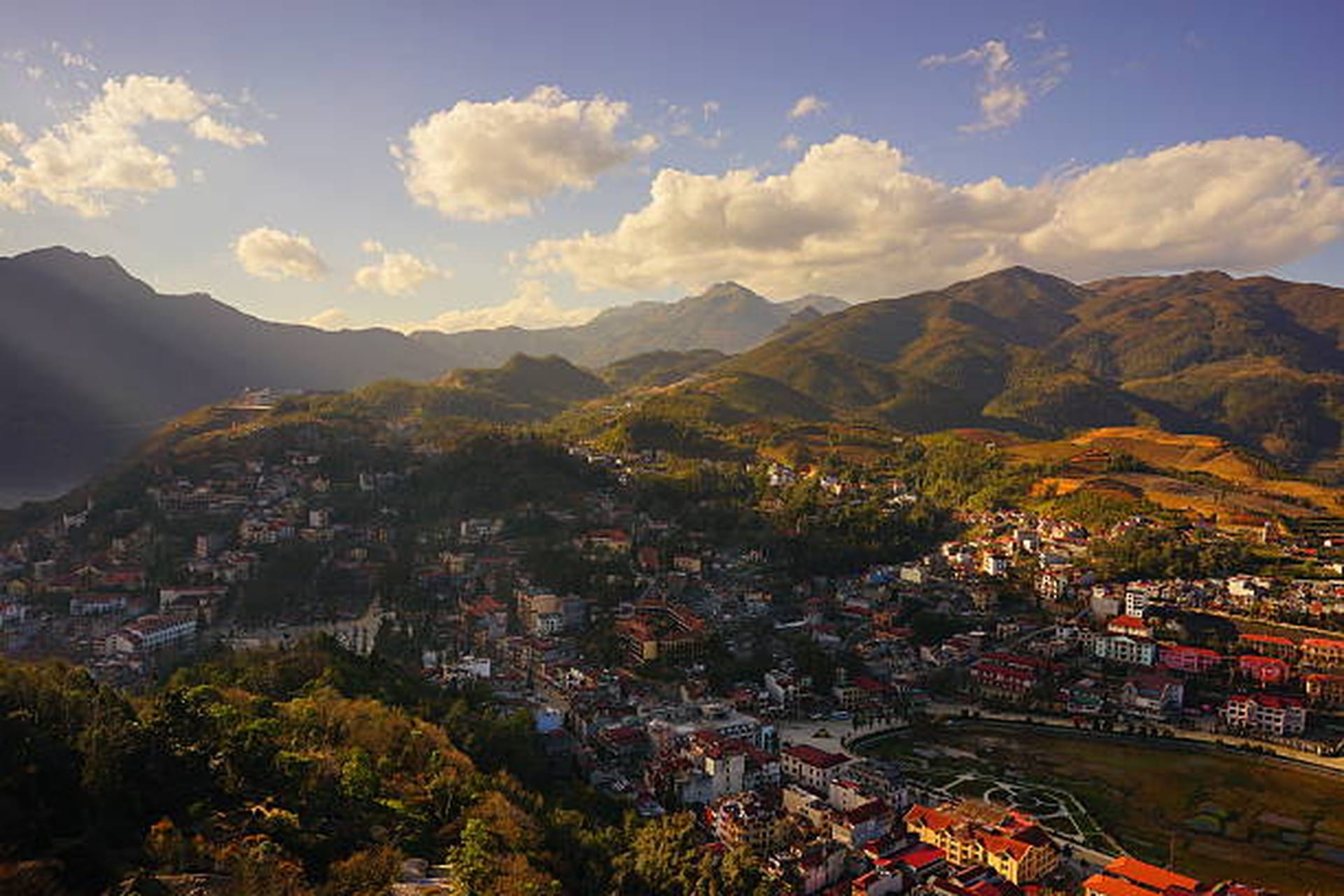 Winding two-lane road cutting through green terraced hillsides on the approach to Sapa.