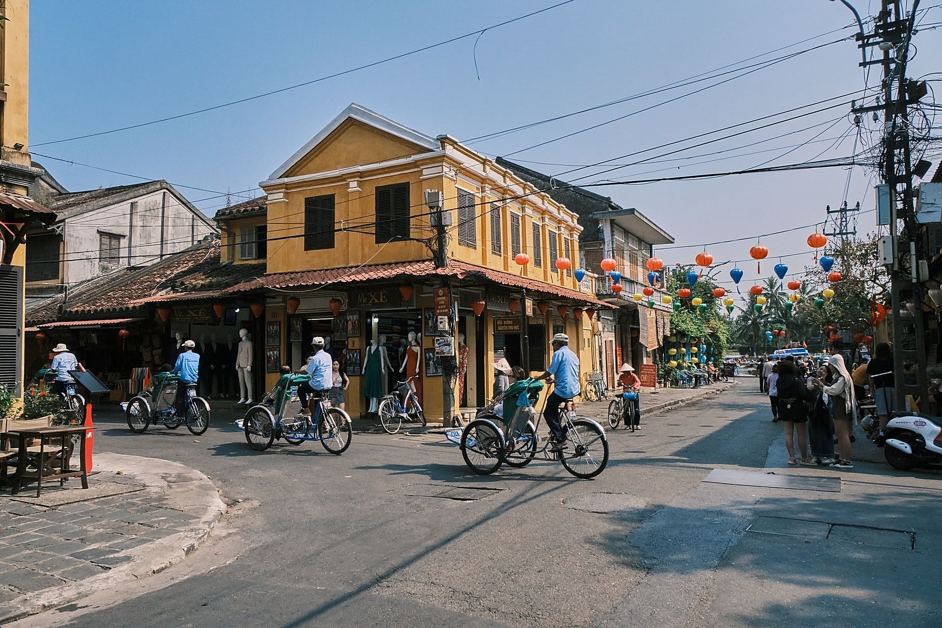 Stalls strung with red and yellow paper lanterns line a busy street at Hoi An's night market.