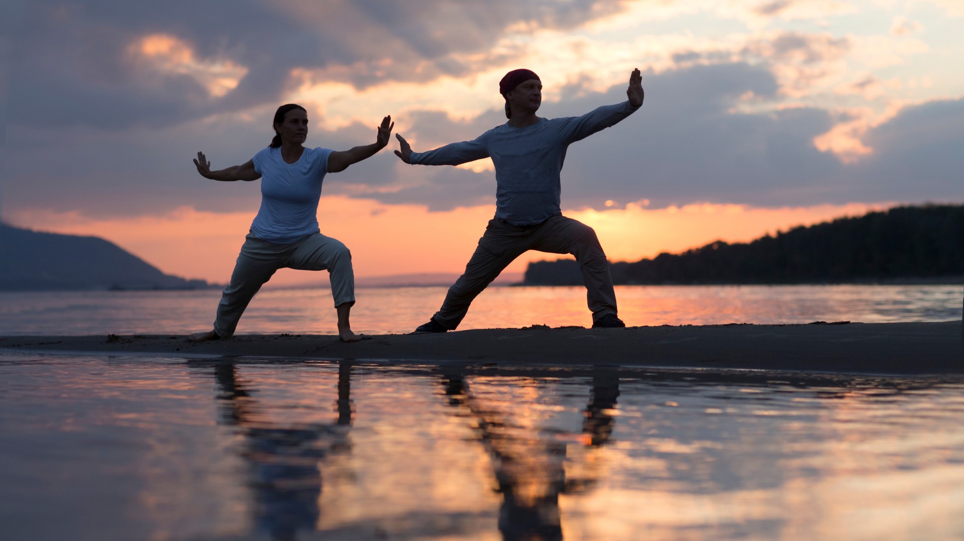 A group practices tai chi in a line on a cruise ship deck, misty karst islands in the background.
