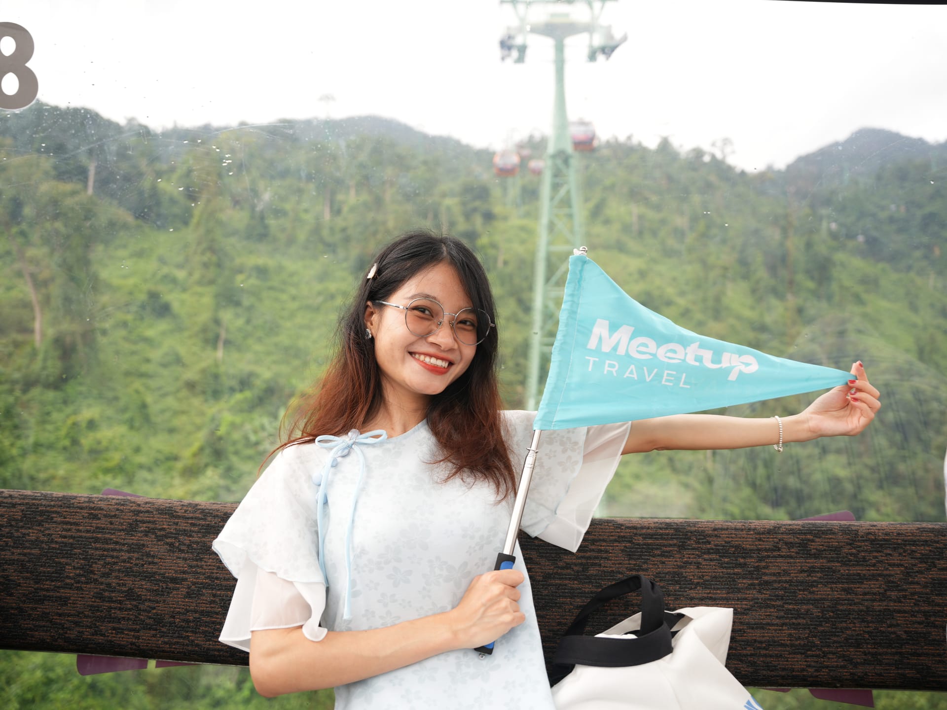 Female tourist holding a flag at Ba Na Hills viewpoint Da Nang