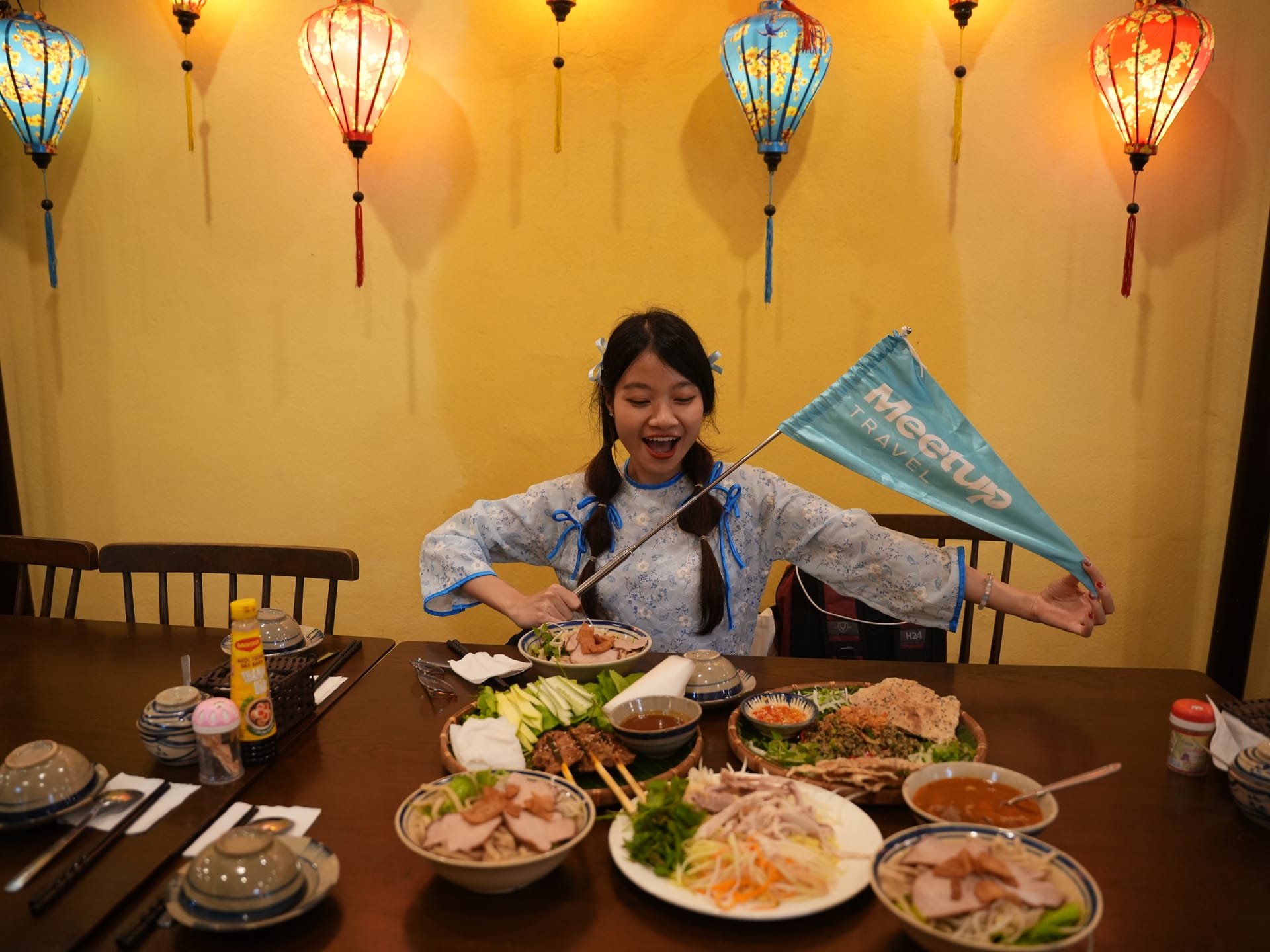 A restaurant terrace in Hoi An Old Town lined with traditional timber shophouses and lanterns.