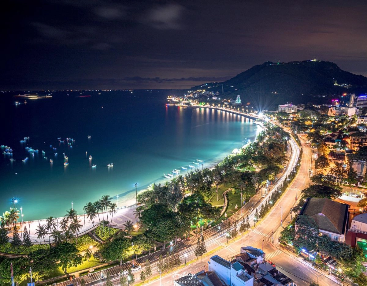 Panoramic night view of Vung Tau coastline and illuminated coastal road near Ho Chi Minh City.