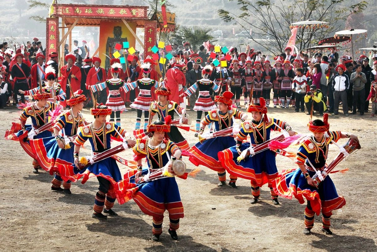 Dao ethnic people performing traditional folk dance in colorful ceremonial outfits during a cultural festival.