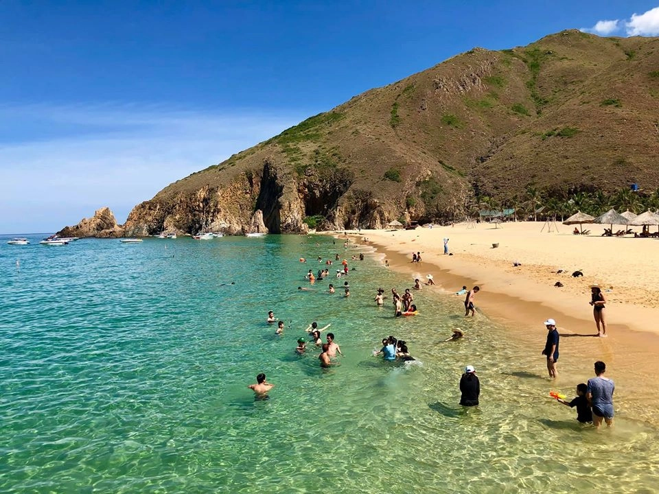 Tourists swimming at a beautiful tropical beach in Vietnam with crystal clear water